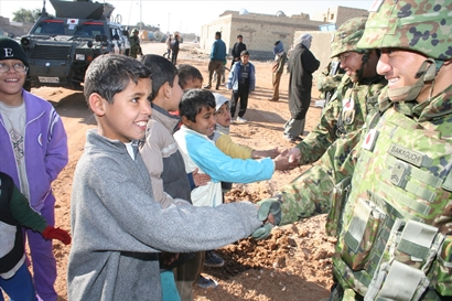 Iraqi children shake hands with SDF soldiers during a reconstruction operation in postwar Iraq. © Rikujojieitai Boueisho (CC BY-SA 3.0)